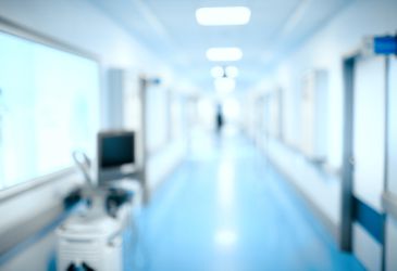 Moderner Krankenhausflur mit medizinischem Personal im Hintergrund, Symbol für Gesundheitsversorgung und Klinikalltag.