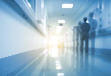 Unscharfer Krankenhausflur mit Personen im Hintergrund, Symbolbild für Klinikalltag und medizinische Versorgung