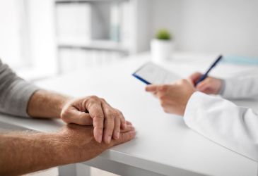 Ärztliches Beratungsgespräch mit Patientenhänden und Dokumentation auf Klemmbrett